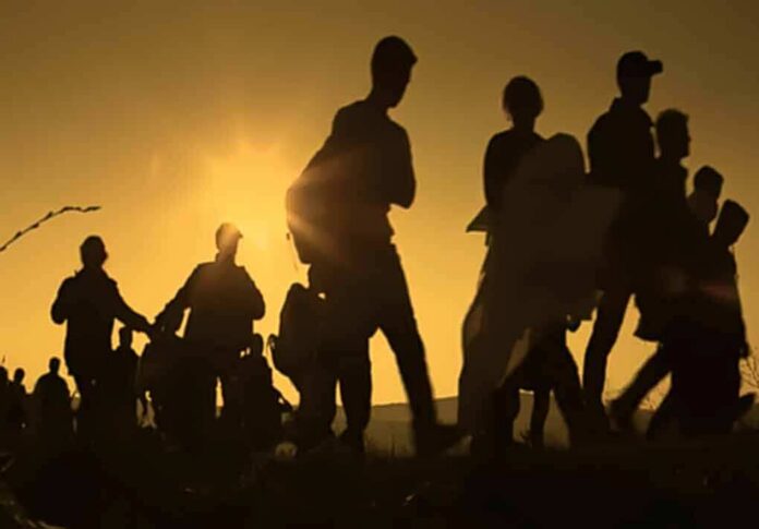 Silhouettes of people walking at sunset