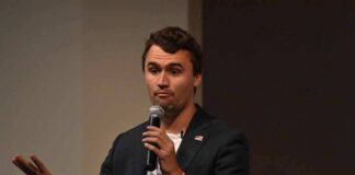 man speaking into a microphone on stage