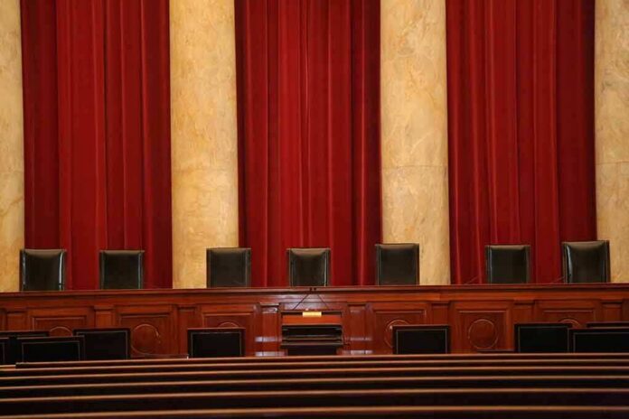 shutterstock_1385367800-5 Empty courtroom bench with red curtains and leather chairs