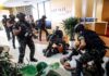 Tactical police detain suspects in an office lobby