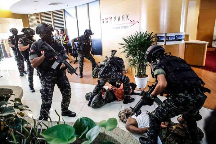 shutterstock_1469942693-2 Tactical police detain suspects in an office lobby