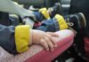 baby hand resting on a pink car seat