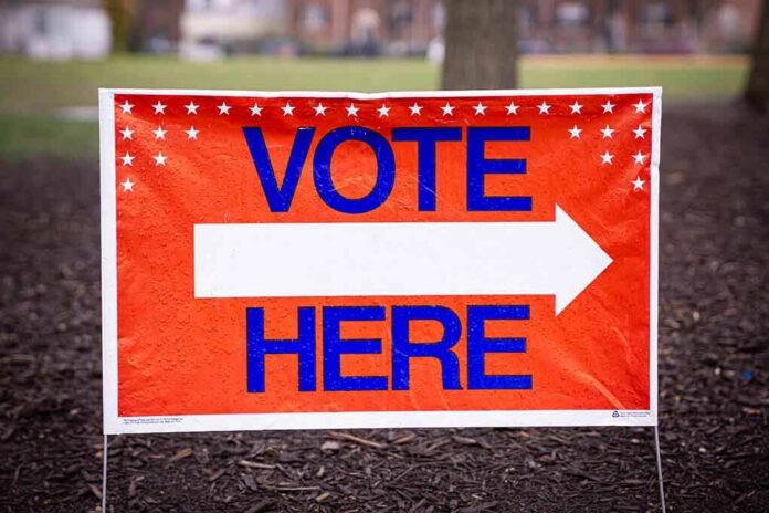 Vote here sign with right-pointing arrow outdoors