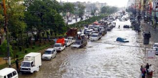 Flooded city street with stranded vehicles and traffic jam