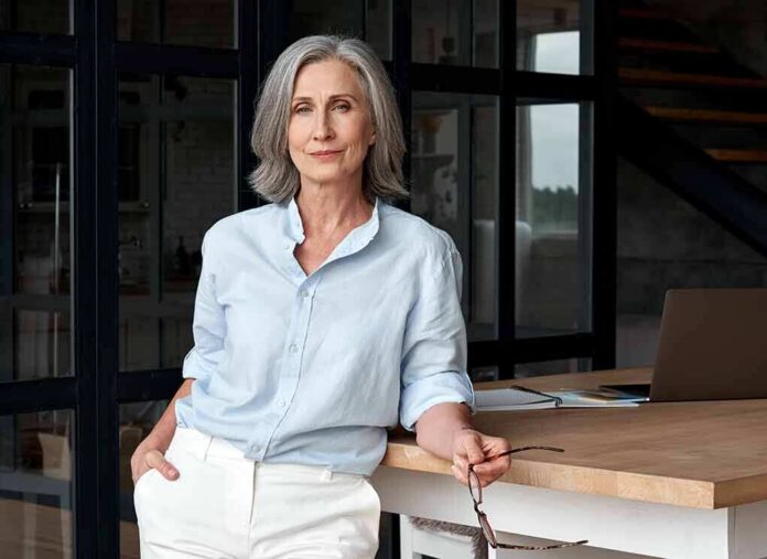 Confident woman standing by a desk in a modern office