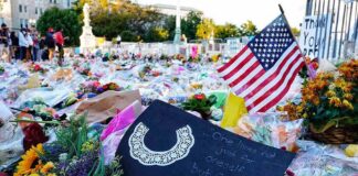 Memorial site with flowers and a U.S. flag