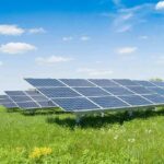Solar panels in a field under a blue sky