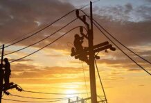 Total Grid Collapse Stuns Cuba Utility workers on power poles at sunset
