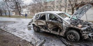 burned-out car with severe damage on a city street