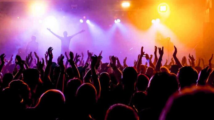 shutterstock_214402048-5 Crowd at a concert with raised hands and colorful stage lights