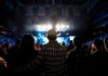 Country Star Backlash Erupts After Kimmel Cowboy-hatted man watches a concert in a packed arena