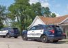 Two police SUVs parked near a suburban house