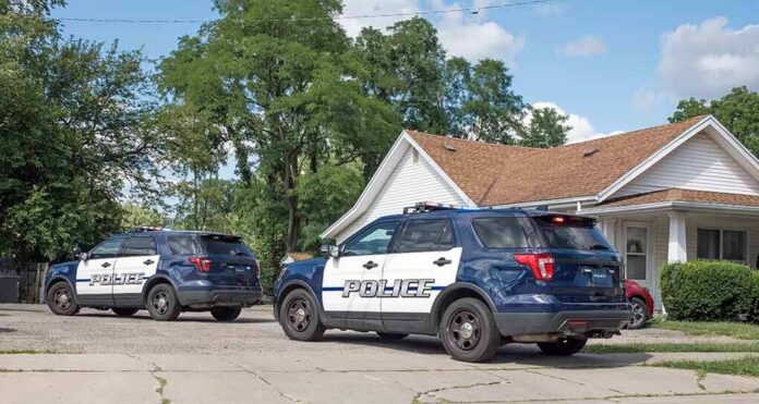 shutterstock_2195086633-5 Two police SUVs parked near a suburban house