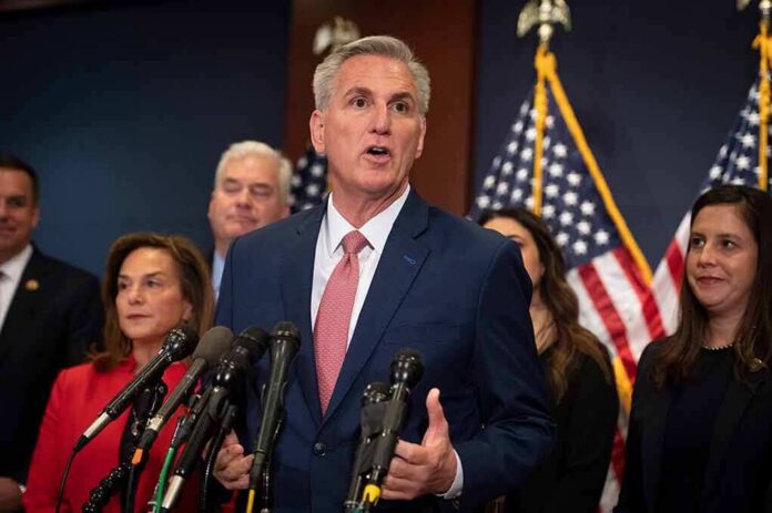 Kevin McCarthy speaks at a podium with Elise Stefanik, Tom Emmer, and Richard Hudson behind him