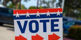 Election sign with the word VOTE and red arrows