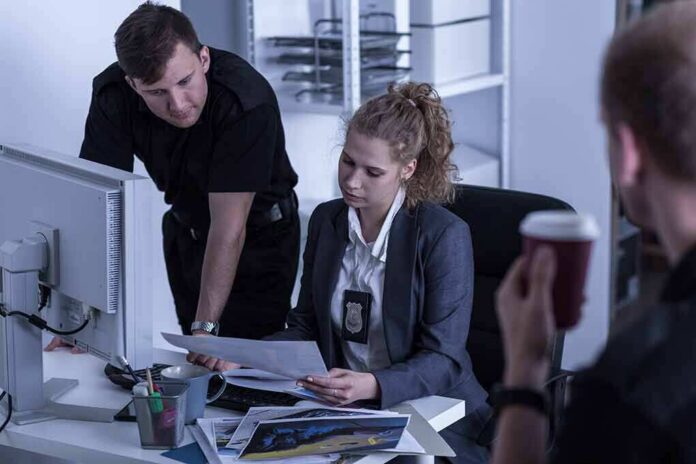 Police officers reviewing documents at a desk