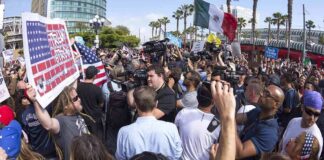 crowd of protesters and media at a street demonstration