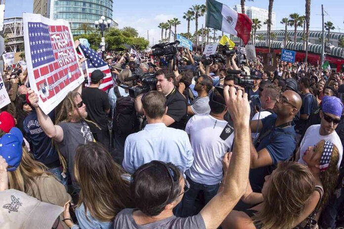 crowd of protesters and media at a street demonstration