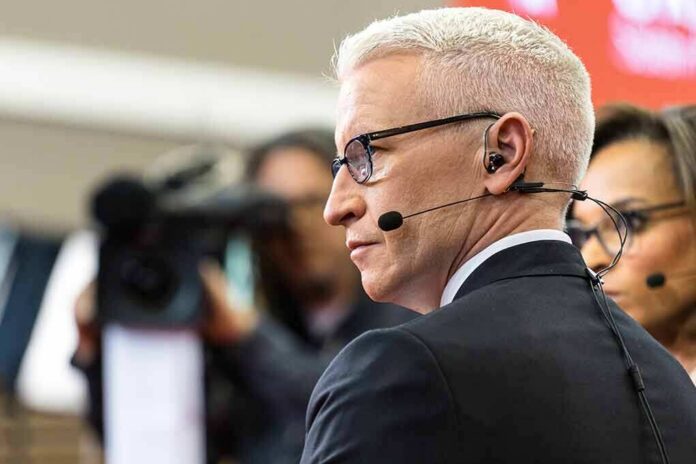 man in headset and glasses speaking into a microphone