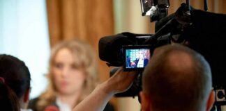 tv camera films interview with blurred speaker
