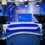 Fox News Host Ignites Outrage With Controversial Advice A television studio setup with cameras and a blue backdrop