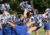 cheerleaders performing with blue and white pom-poms
