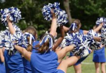 cheerleaders performing with blue and white pom-poms