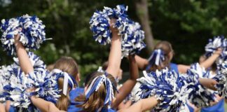 cheerleaders performing with blue and white pom-poms