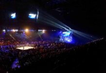 Wrestling ring in a packed arena with stage lights