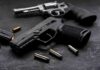 Twin Cities Officials Push New Gang Task Force Handgun and revolver with scattered bullets on dark surface