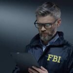 FBI agent in jacket using a tablet