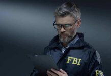 FBI agent in jacket using a tablet