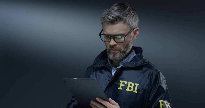 FBI agent in jacket using a tablet