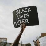 History Exhibit or Shrine to Cop Killers? Protester holds a handwritten sign aloft at a rally