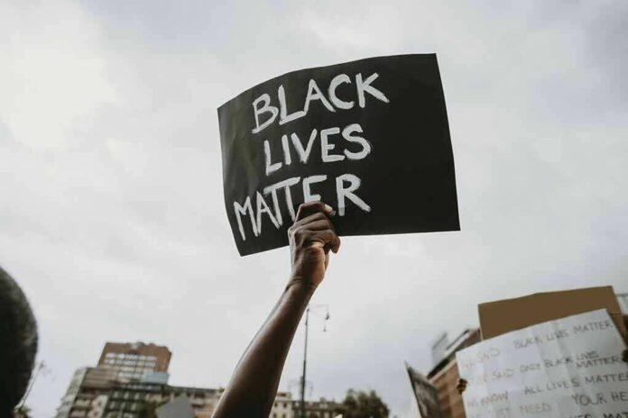 shutterstock_1752257708 Protester holds a handwritten sign aloft at a rally