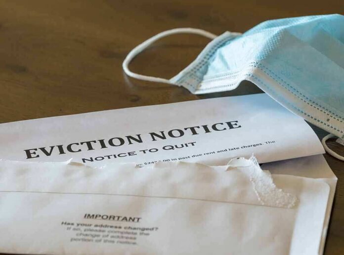 shutterstock_1772208584 Eviction notice and torn envelope beside blue surgical masks