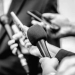 Chilling Ultimatum Over Dessert – Douglas Rattled Microphones and recorders held toward a speaker