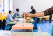 Venezuela Playbook Exposes E-Vote Weak Spot Hand casting ballot into a box at a polling station