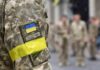 Soldier in camouflage with Ukrainian flag patch and yellow armband