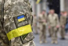 Sealed Evidence, Open Diplomacy – What’s Hiding? Soldier in camouflage with Ukrainian flag patch and yellow armband