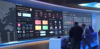 cybersecurity operations room with large data dashboards and people discussing