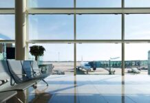 Airport terminal with plane at gate viewed through large windows