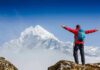 Cliff Band Claim Shocks Mount Morgan Hiker with arms raised facing snowy mountain peak
