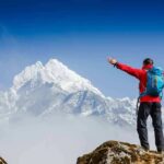 Cliff Band Claim Shocks Mount Morgan Hiker with arms raised facing snowy mountain peak
