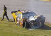 Race car with heavy front-end damage on grass