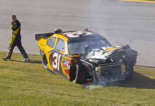 Race car with heavy front-end damage on grass