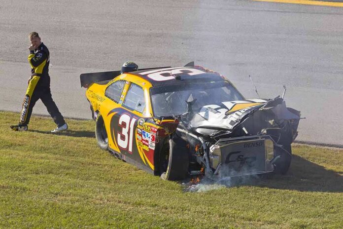 Race car with heavy front-end damage on grass