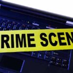 Laptop keyboard with yellow crime scene tape across it